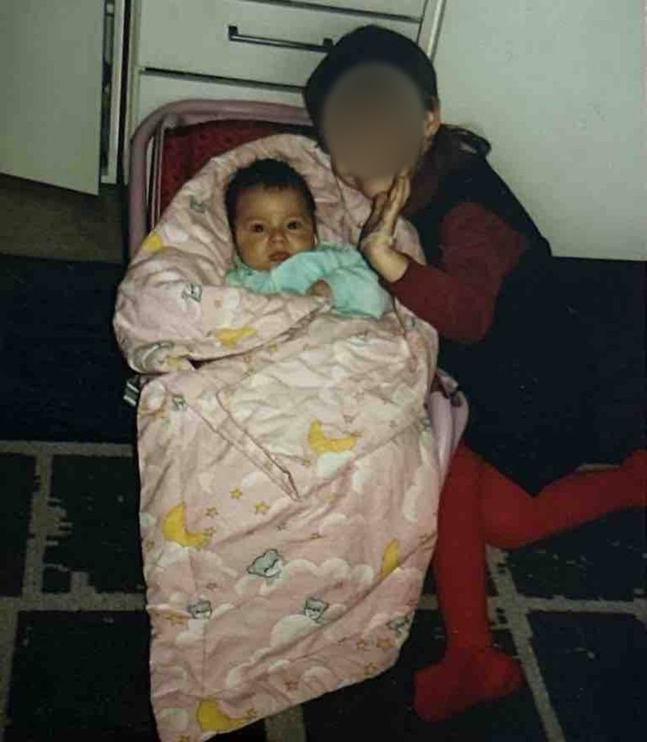Daniel as a baby held by an older child