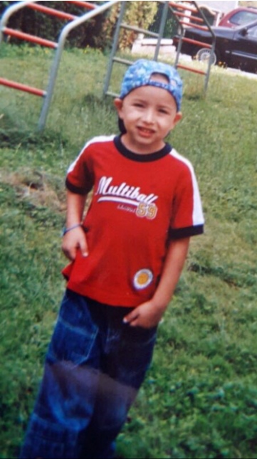 Daniel as a child, cap backwards on a climbing frame