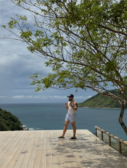 Daniel on a wooden deck overlooking the ocean