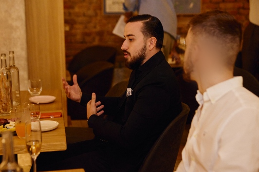 Daniel in conversation at a dinner