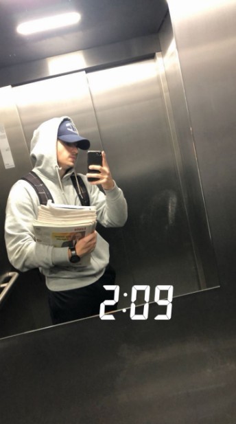 Daniel in an elevator at 2:09am with newspapers